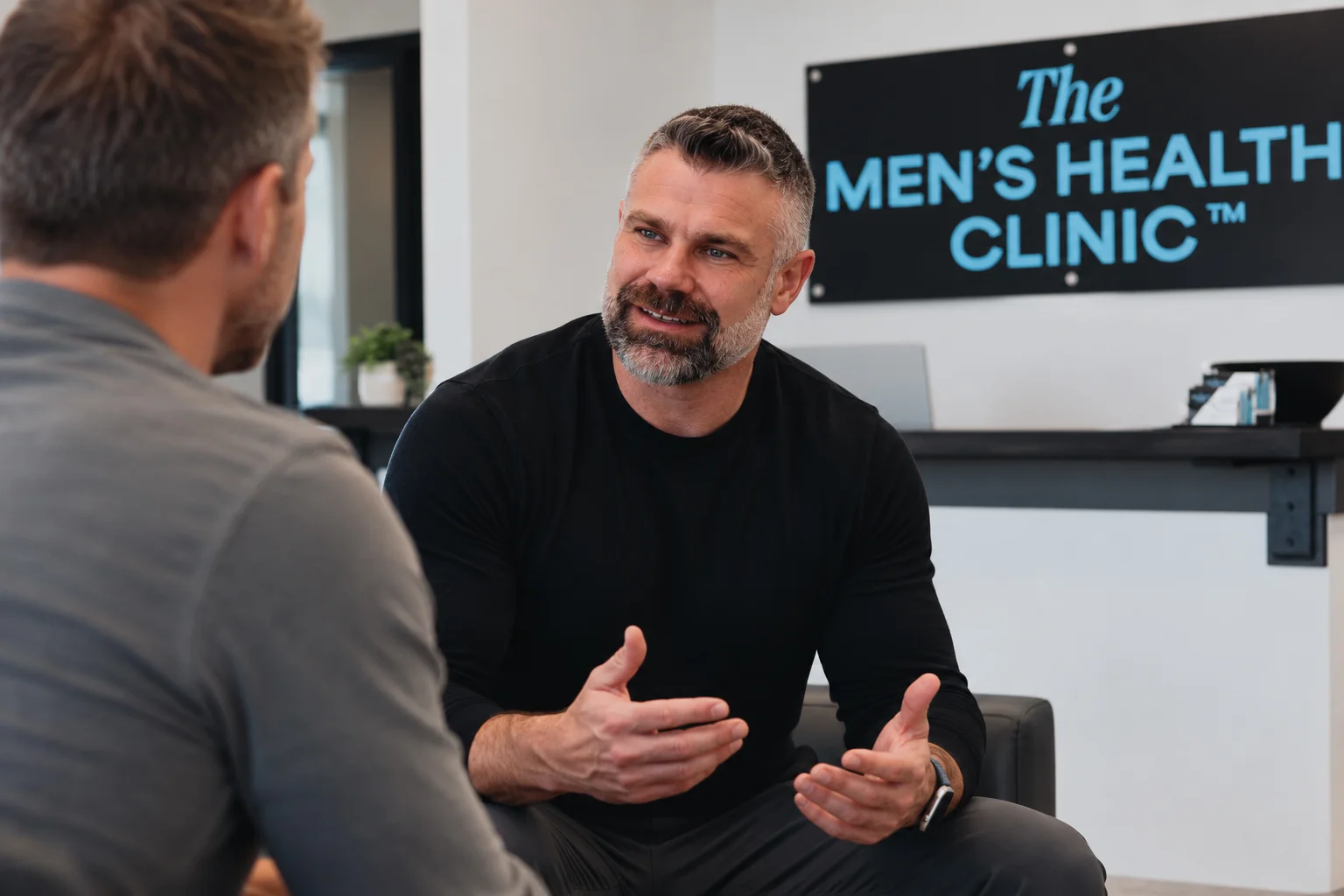 Erik talking with a visitor at The Men's Health Clinic